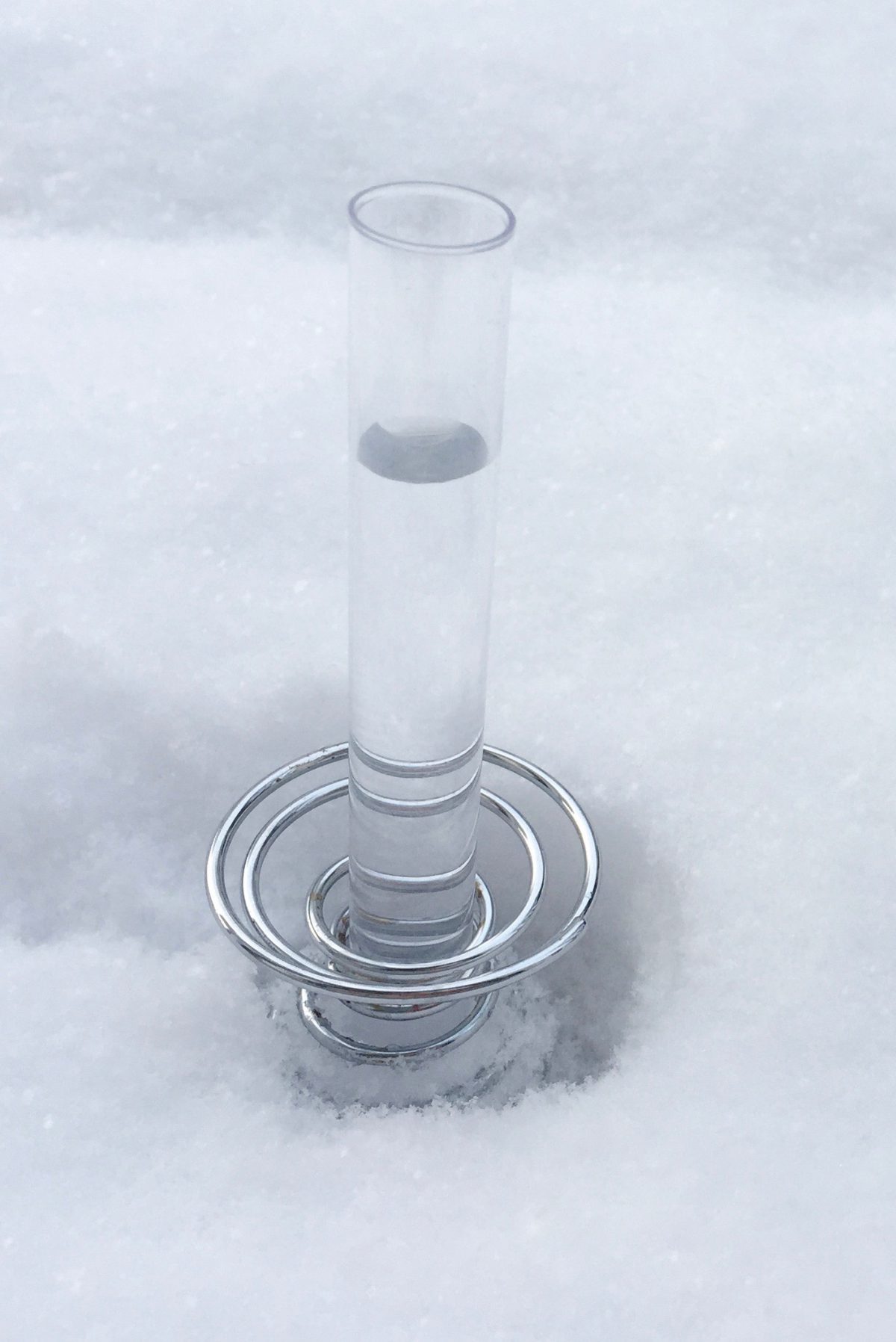 Ein Wasserglas steht im Schnee.