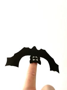 Schwarzer Vampir fliegt zauberhaft auf einem Finger